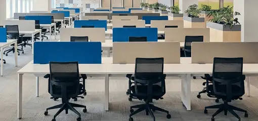 Modern open-plan office space featuring clean workstations, ergonomic chairs, and sanitized carpets provided by professional office cleaning services in Nashua, NH.